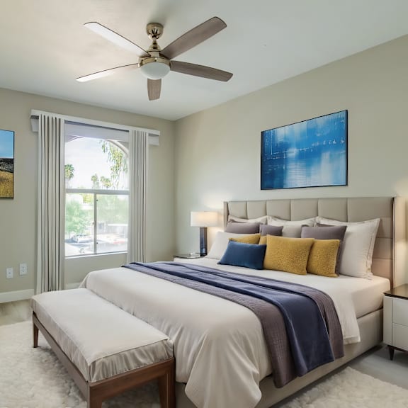 a bedroom with a large bed, a ceiling fan, and two pictures on the wall at sofia apartments, tempe, 85283