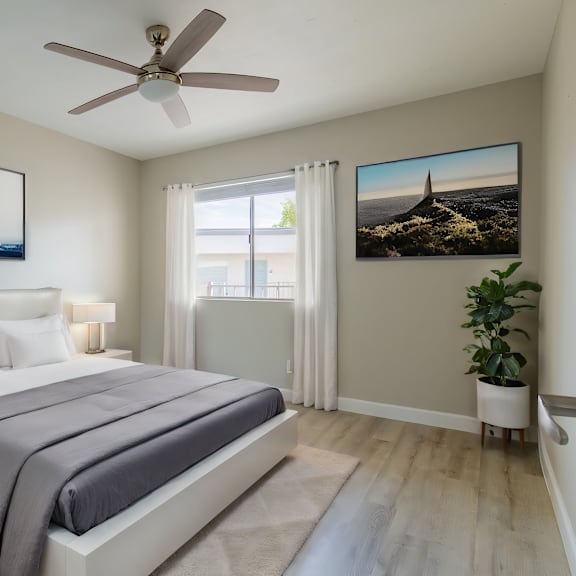 a bedroom with a large bed, a ceiling fan, and a painting on the wall at sofia apartments, tempe, 85283