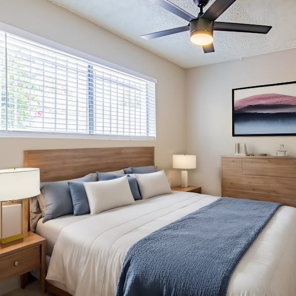 a bedroom with a large bed and a ceiling fan