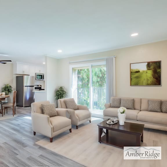 a spacious living room with a dining area and a kitchen in the background.