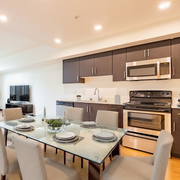 a living room with a table and chairs and a kitchen