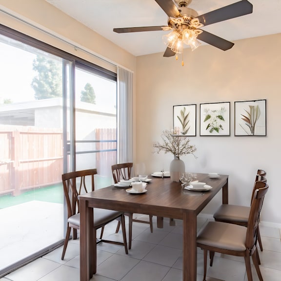 a dining room with a table and chairs and a ceiling fan