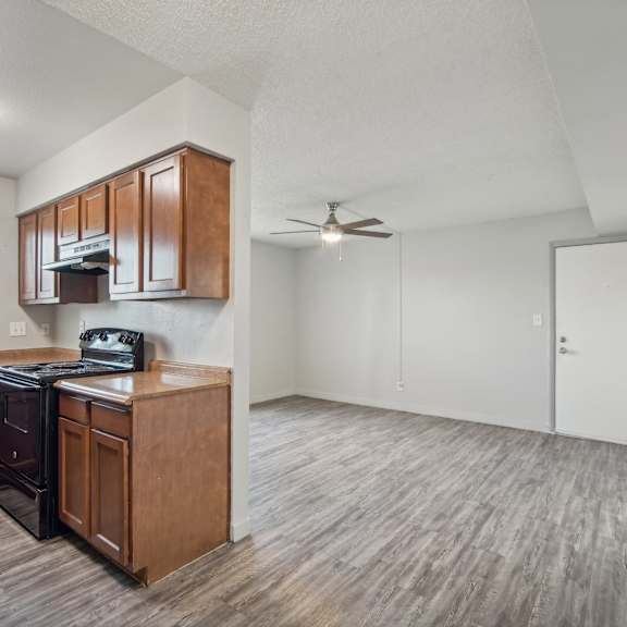 an empty kitchen and living room with a ceiling fan