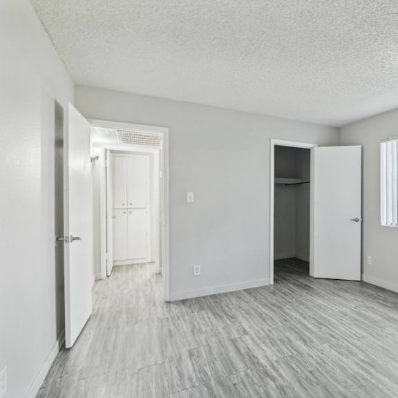 an empty living room with white walls and wood flooring