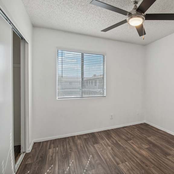 the living room of our studio apartment atrium with a ceiling fan and a window