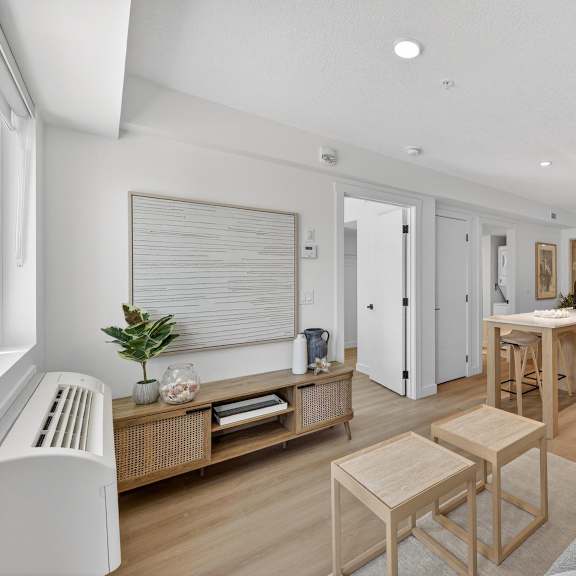 a living room with a grey couch and wooden furniture.