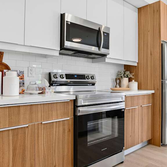 a modern kitchen with wooden cabinets and stainless steel appliances.