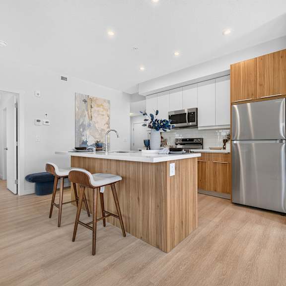 a modern kitchen with wooden cabinets and a stainless steel refrigerator.
