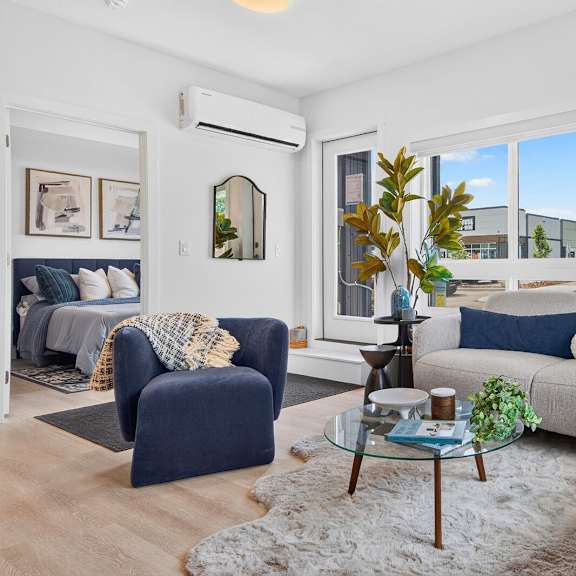 a living room with a blue chair and a grey couch.