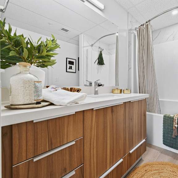a bathroom with a white countertop and wooden drawers.