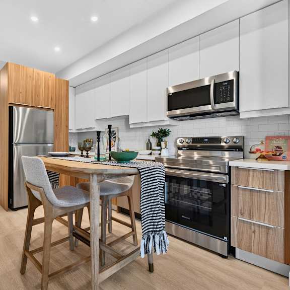 a modern kitchen with a wooden island and stainless steel appliances.