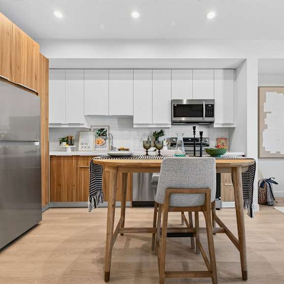 a modern kitchen with a wooden table and chairs.