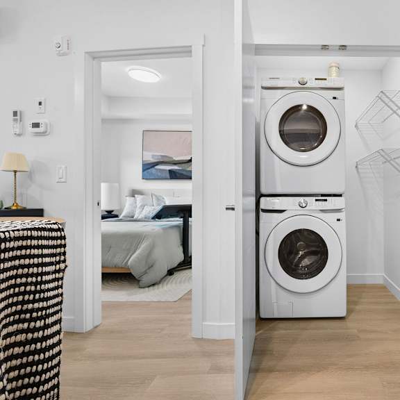 a modern laundry room with a washer and dryer built into the wall.