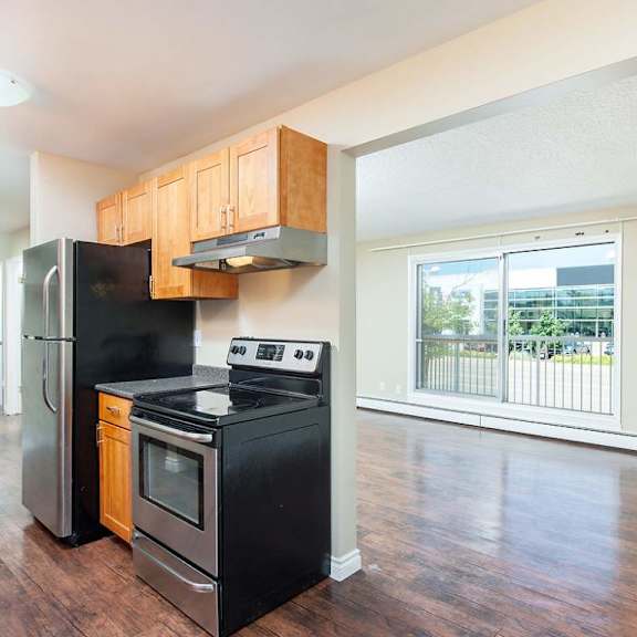 a kitchen with black appliances and wooden cabinets.