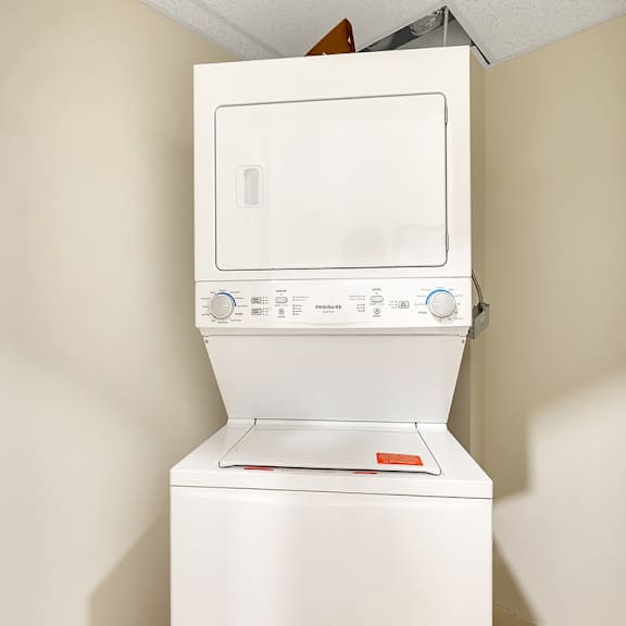 a white washing machine in a small room.