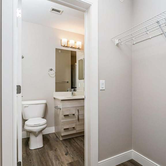 a white toilet is in a small bathroom with a white sink and a towel bar.