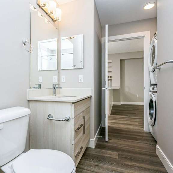 a white toilet sits in a bathroom next to a sink and a mirror.