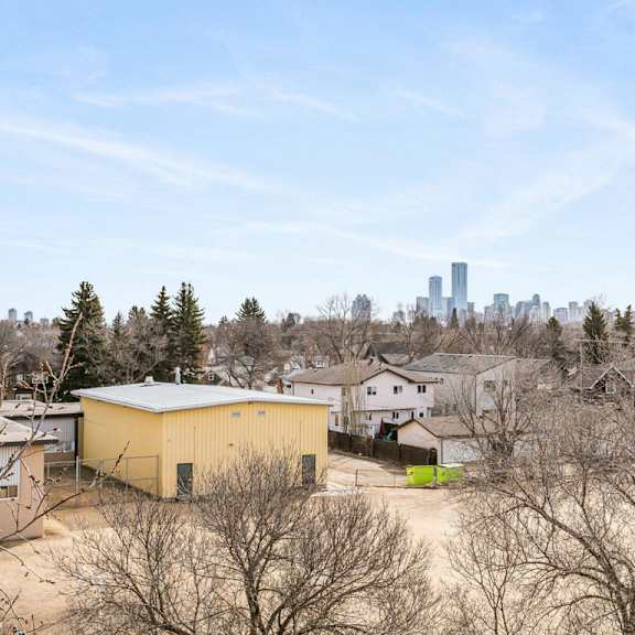 a yellow building is in the foreground with a city skyline in the background.