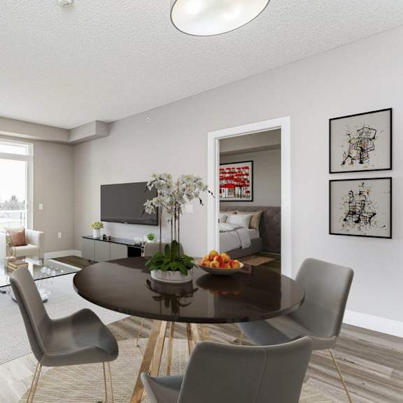a modern living room with a glass table and grey chairs.