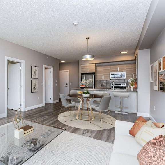 a modern living room with a glass coffee table and a flat screen tv.