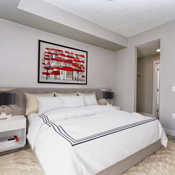 a bedroom with a large bed and a framed picture on the wall.