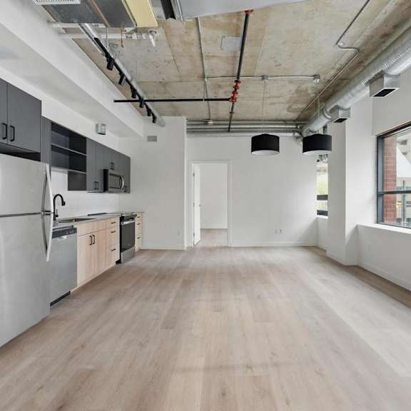 a kitchen with a refrigerator, oven, and cabinets.