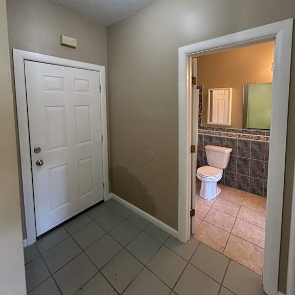 a bathroom with a white door and a skylight above it.
