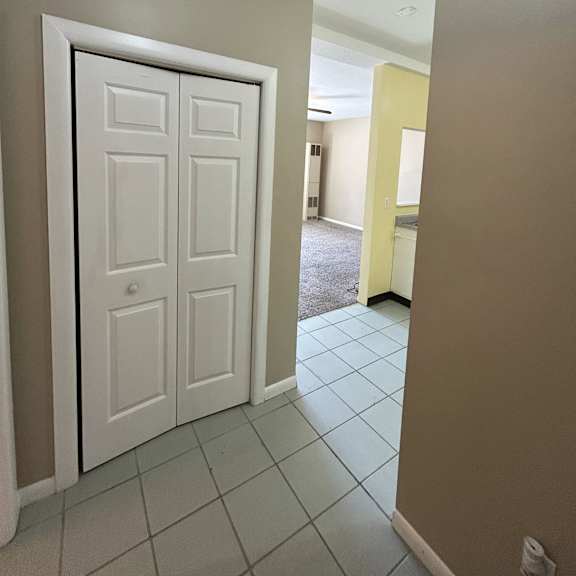 a white door in a room with a tiled floor.