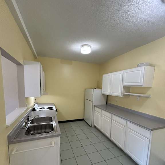 a kitchen with white appliances and a white ceiling.