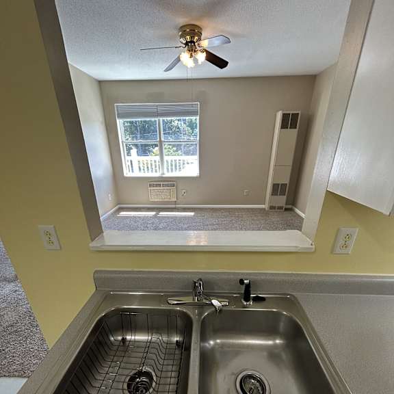 a stainless steel sink with a drain in the middle is installed in a wall.