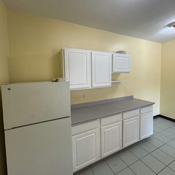 a white cabinet with a door is in the middle of a room.