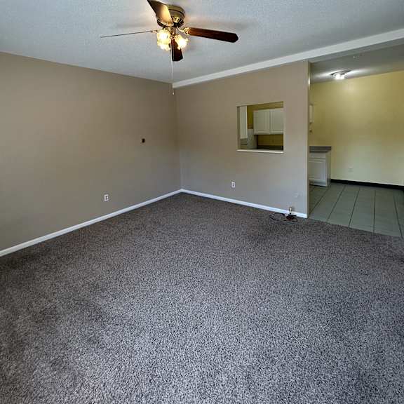 a small room with a ceiling fan and a mirror.