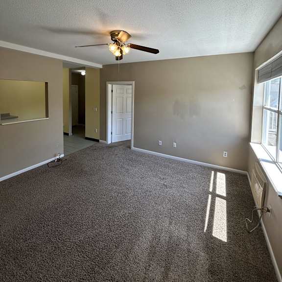 a wall with a light switch and a ceiling fan.