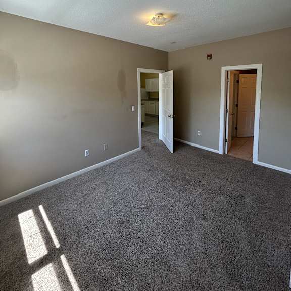 a white wall with a light switch and a window.