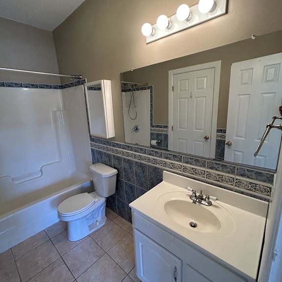 a bathroom with a white tub and toilet.