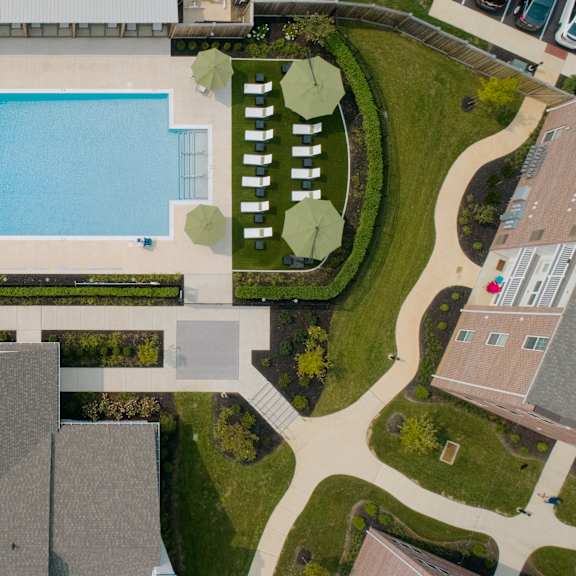 a swimming pool surrounded by a grassy area and a building.