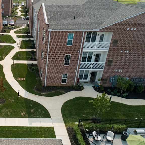 a view of a courtyard between two red brick apartment buildings.