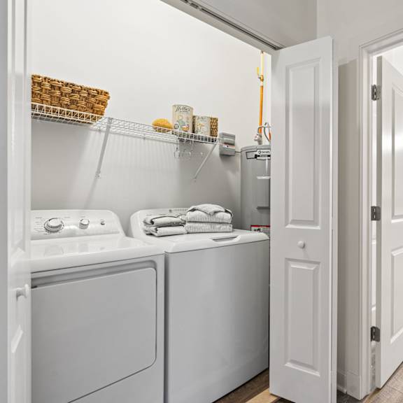 a white bathroom with a washer and dryer built in.