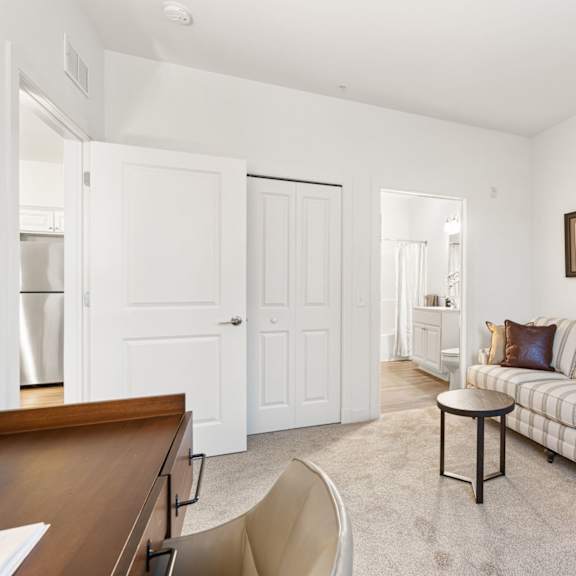 a living room with a couch, chair, and two pictures on the wall.