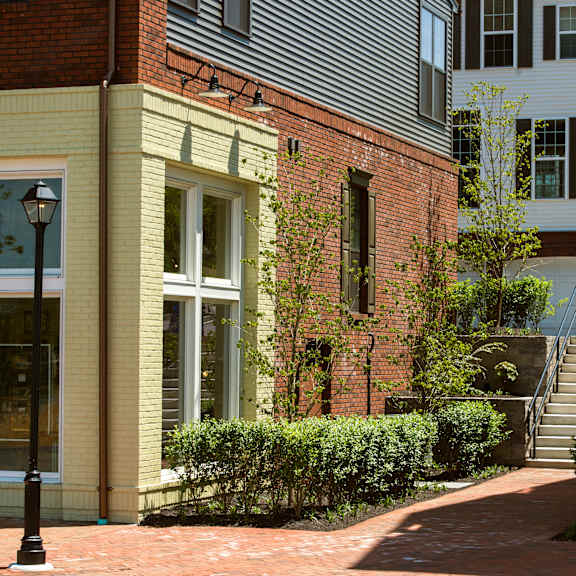 a building with a yellow wall and a black lamp post.