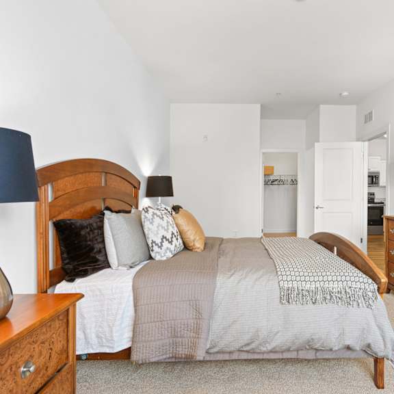 a bedroom with a bed, dresser, and mirror.