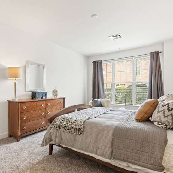 a bedroom with a bed, dresser, and mirror.