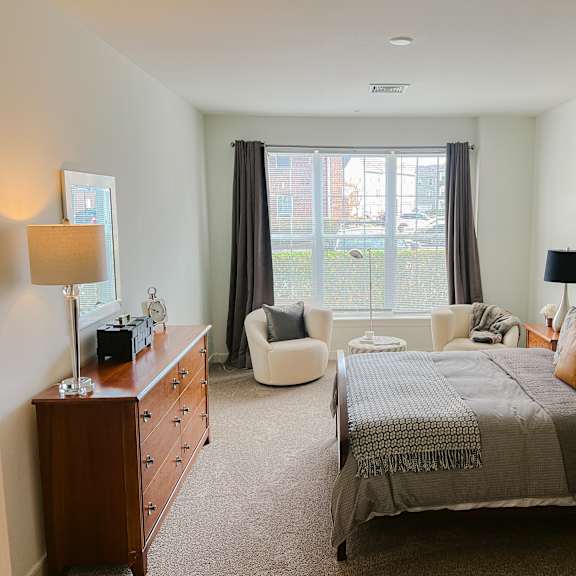 a bedroom with a large bed and a chair.