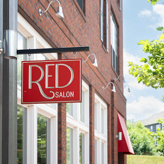 a red sign with the word "red" on it is hanging from a building.