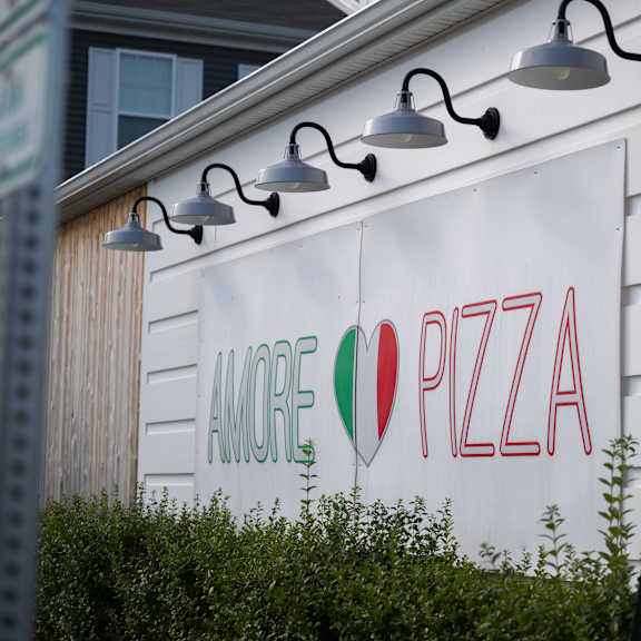 a sign for amore pizza is displayed on a building.