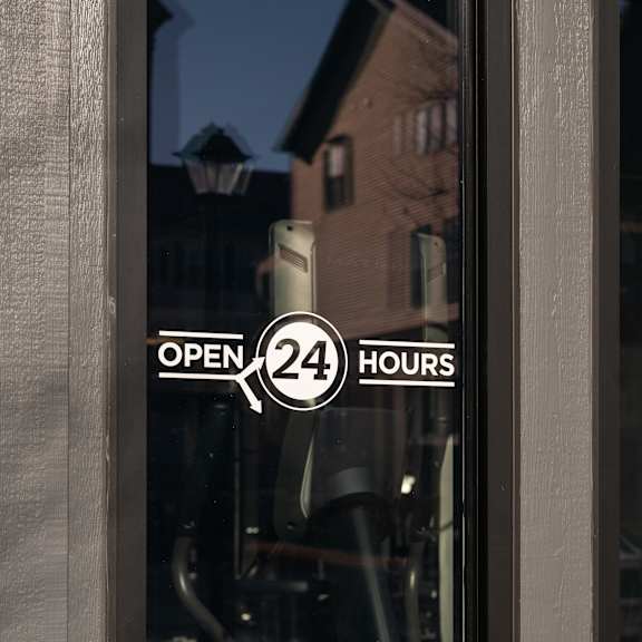 a window with a sign that says open 24 hours.