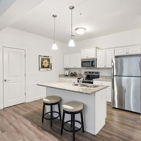 a kitchen with a white counter and a refrigerator.