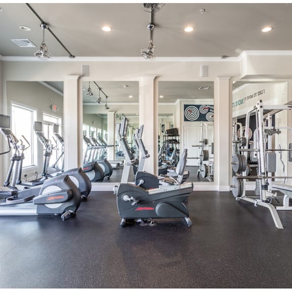 a gym with treadmills, elliptical machines, and weight machines.
