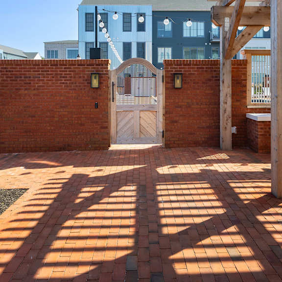 a blue building with a white door and a wooden pergola.