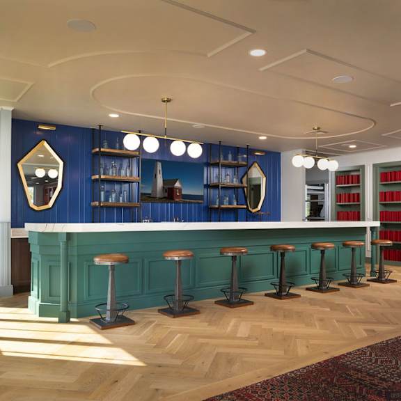 a bar with a green counter and stools is shown.